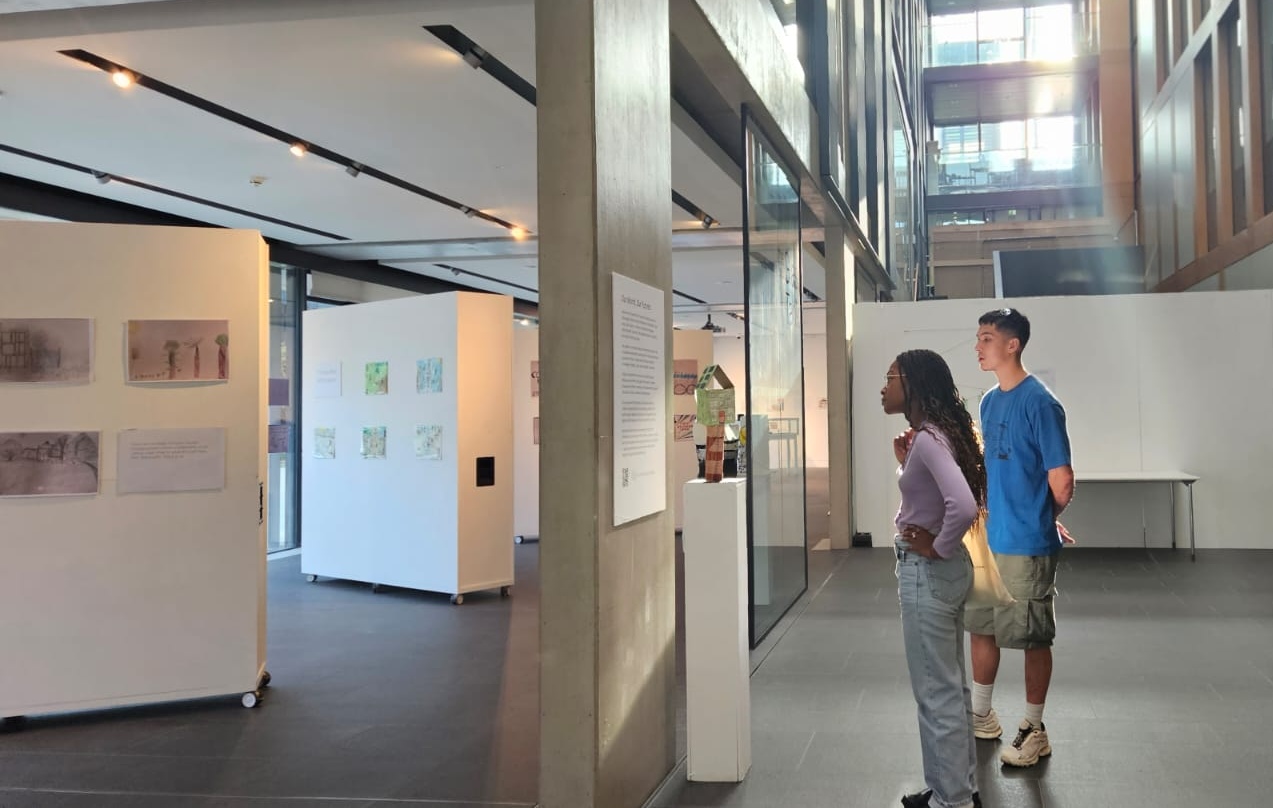 Two young people read an information panel about an exhibition