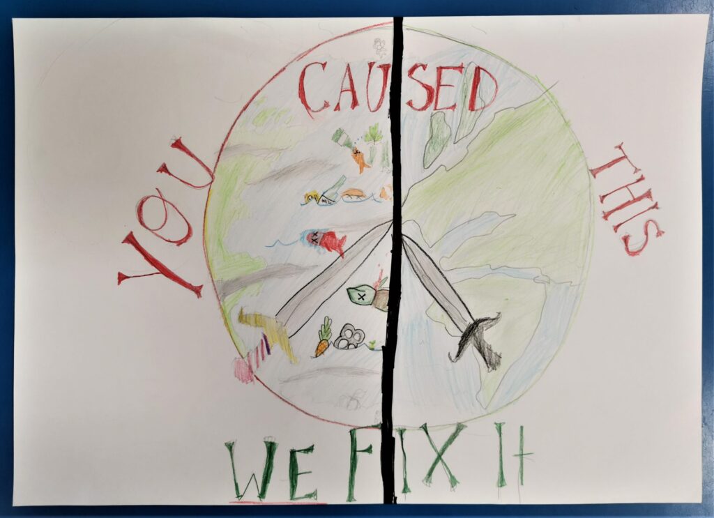 A poster created with coloured pencil and felt pen. Image: A circle is divided into two vertically by a stark black line. The left hand side shows fish killed by plastic pollution. The right hand side shows a map of the earth. Two swords at diagonals allude to the CND sign. The words "YOU CAUSED THIS" in red and "WE FIX IT", in green, surround the circle.
