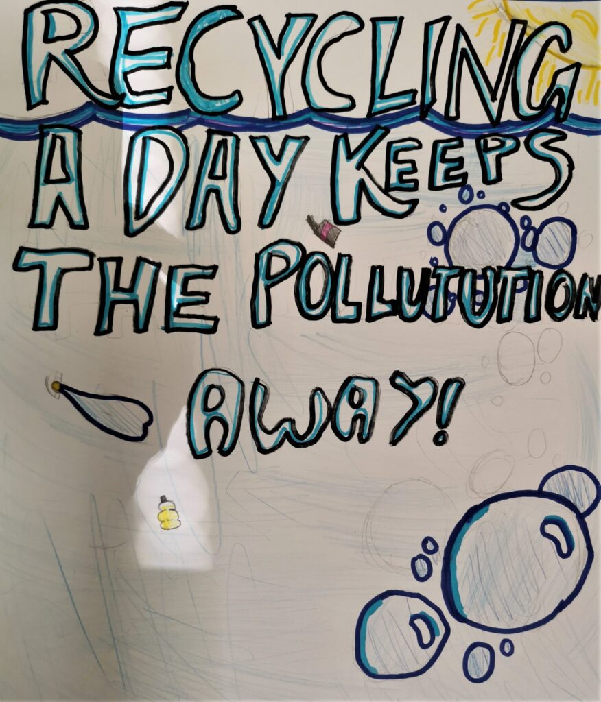 A poster created with felt pen and coloured pencil. Bold text reads: "Recycling a day keeps the pollution away!" Behind the text, the sun shines over the wavy surface of the sea. Below the surface can be seen bubbles and plastic litter.